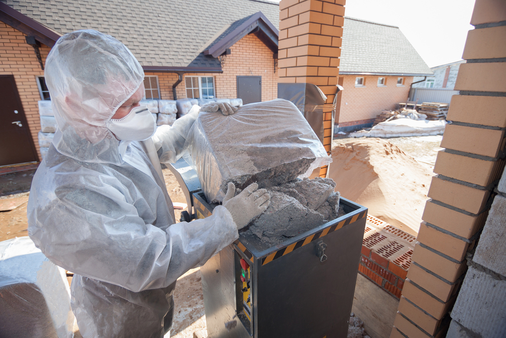 Installer placing blow-in insulation into a blowing machine