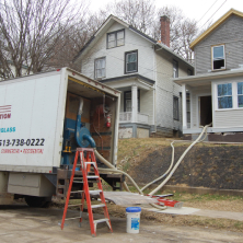 Valley Insulation truck outside of a home with tubes for blowing cellulose insulation