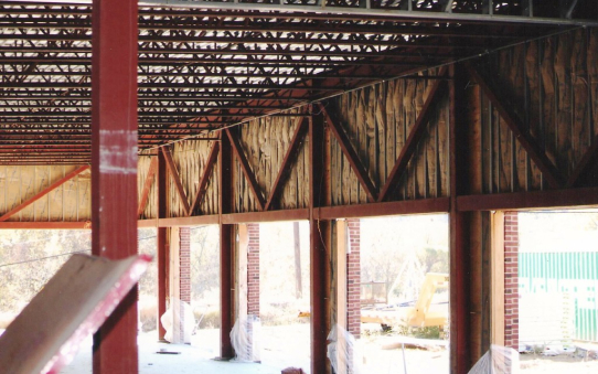 Commercial building with batts of insulation being installed