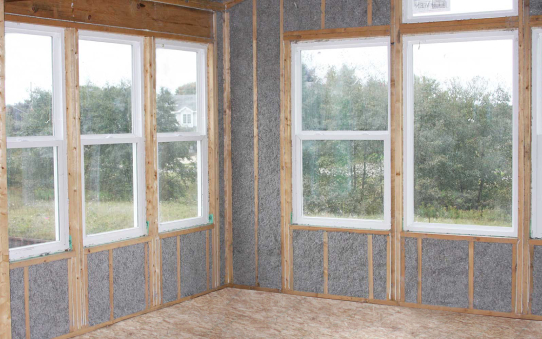 Corner room in a home filled with gray cellulose insulation