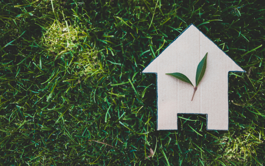 Cardboard cutout of home against green grass