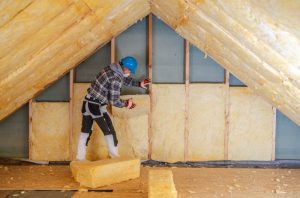 A worker installing attic insulation
