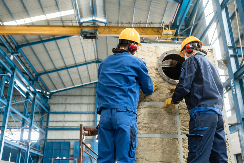 Workers installing industrial insulation
